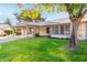 Charming single-story home with a carport, lovely lawn, and mature trees on a sunny day at 11671 S Jokake St, Phoenix, AZ 85044