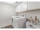 Bright laundry room equipped with modern washer, dryer, and ample cabinet space at 11671 S Jokake St, Phoenix, AZ 85044