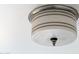 Image of a vintage ceiling light fixture with a rounded white shade, accented by dark horizontal bands at 1309 W Glenrosa Ave, Phoenix, AZ 85013