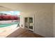 Covered back patio with slider access to a bright pool surrounded by vibrant flowers and an outdoor lounge area at 14401 N 22Nd St, Phoenix, AZ 85022