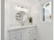 This bathroom features a round mirror, decorative lighting fixture and shelving, and a sleek white vanity at 1621 W Mulberry Dr, Phoenix, AZ 85015