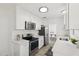 This kitchen boasts a stainless steel refrigerator, electric oven, and white cabinets with light countertops, seamlessly flowing into the dining area at 1621 W Mulberry Dr, Phoenix, AZ 85015