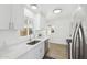 This kitchen features modern stainless-steel appliances, light wood-look flooring, white cabinets and white stone countertops at 1621 W Mulberry Dr, Phoenix, AZ 85015