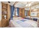 Spacious bedroom boasts wood paneled walls and built-in shelving, illuminated by a modern ceiling fan at 17200 W Bell Rd # 77, Surprise, AZ 85374