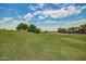 Expansive golf course with manicured green grass, mature trees, and a beautiful blue sky at 17200 W Bell Rd # 77, Surprise, AZ 85374