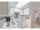 Well-lit kitchen features ample white cabinetry, white appliances, and a window over the sink at 17200 W Bell Rd # 77, Surprise, AZ 85374