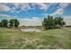 Scenic view of a pond surrounded by green grass and mature trees under a blue sky at 17200 W Bell Rd # 77, Surprise, AZ 85374
