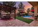 Backyard oasis featuring a sparkling pool, putting green, pergola, and string lights for entertaining at 17541 W Statler Dr, Surprise, AZ 85388
