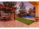 Backyard oasis featuring a sparkling pool, putting green, pergola, and string lights for evening enjoyment at 17541 W Statler Dr, Surprise, AZ 85388