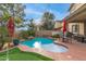 Lush backyard oasis with a sparkling pool, well-maintained putting green, and inviting seating under a red umbrella at 17541 W Statler Dr, Surprise, AZ 85388
