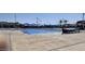 Community pool with canopies, slides, and a lifeguard stand, ready for summer fun at 17541 W Statler Dr, Surprise, AZ 85388