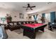 Spacious game room featuring a pool table, comfortable seating, and a ceiling fan for added comfort at 17541 W Statler Dr, Surprise, AZ 85388
