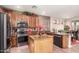 Open kitchen with granite countertops, wood cabinets, stainless steel appliances, and a center island at 17541 W Statler Dr, Surprise, AZ 85388