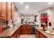 Granite countertops, tile backsplash, and stainless steel dishwasher are highlights of this ample kitchen at 17541 W Statler Dr, Surprise, AZ 85388