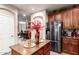 Kitchen island with granite countertop, stainless steel refrigerator, and views into adjacent dining room at 17541 W Statler Dr, Surprise, AZ 85388
