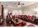 Spacious living room featuring a large brown leather sectional, stylish decor and ceiling fan at 17541 W Statler Dr, Surprise, AZ 85388