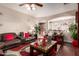 Open living room with hardwood floors, a large leather sectional, ceiling fan and archway to dining area at 17541 W Statler Dr, Surprise, AZ 85388