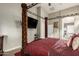 Spacious main bedroom featuring a four-poster bed, TV, and access to the en-suite bathroom at 17541 W Statler Dr, Surprise, AZ 85388