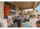 Covered patio with comfortable seating, a ceiling fan, and a view of the well-manicured backyard at 17541 W Statler Dr, Surprise, AZ 85388