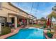 Stunning backyard with a vibrant pool, manicured landscaping, outdoor kitchen, and a covered patio, perfect for relaxation at 17541 W Statler Dr, Surprise, AZ 85388