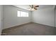 A clean and spacious bedroom with a ceiling fan and a large window at 1763 W Pepper Pl, Mesa, AZ 85201