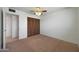 Bedroom with a ceiling fan, carpet floors, and closet at 1763 W Pepper Pl, Mesa, AZ 85201
