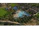 Stunning aerial view of community pool, splash pad, playground, and clubhouse amenities surrounded by lush landscaping at 1828 W Sheridan Ave, Apache Junction, AZ 85120