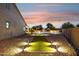 Beautiful backyard with in-ground pool, grass area, desert landscaping and outdoor lighting at 18324 W Highland Ave, Goodyear, AZ 85395