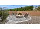 Inviting outdoor fire pit area with comfortable seating surrounded by lush landscaping and a privacy wall at 18324 W Highland Ave, Goodyear, AZ 85395