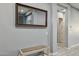 A home's hallway features a bench and a large mirror enhancing the sense of space at 18324 W Highland Ave, Goodyear, AZ 85395