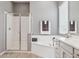 Bright primary bathroom with double vanity, garden tub and glass enclosed shower at 18324 W Highland Ave, Goodyear, AZ 85395