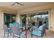 Relaxing covered patio with comfortable blue cushioned chairs and a ceiling fan for outdoor living at 18324 W Highland Ave, Goodyear, AZ 85395