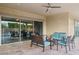 Cozy covered patio with woven furniture, blue cushions, and seamless access to the home's interior at 18324 W Highland Ave, Goodyear, AZ 85395