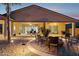 Spacious covered patio with firepit, ample seating area, desert landscaping and outdoor lighting at 18324 W Highland Ave, Goodyear, AZ 85395