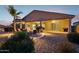 Spacious covered patio with firepit, ample seating area, desert landscaping and outdoor lighting at 18324 W Highland Ave, Goodyear, AZ 85395