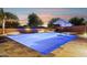 Inviting in-ground pool with a sun shelf, bistro table and desert landscaping with a sunset sky at 18324 W Highland Ave, Goodyear, AZ 85395