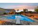 Inviting backyard pool with diving board, sun umbrellas, and plenty of poolside seating for relaxing or entertaining at 18324 W Highland Ave, Goodyear, AZ 85395