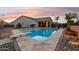 Inviting in-ground pool with a diving board and lounge chairs surrounded by desert landscaping at 18324 W Highland Ave, Goodyear, AZ 85395