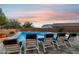 Relaxing poolside view with lounge chairs, in-ground pool and a colorful sky at dusk at 18324 W Highland Ave, Goodyear, AZ 85395