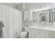Clean bathroom featuring a shower with curtain, white vanity, and ample lighting at 18327 N Summerbreeze Way, Surprise, AZ 85374