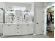 Bright bathroom with dual sinks, a walk-in shower, and a door leading to a walk-in closet at 18327 N Summerbreeze Way, Surprise, AZ 85374