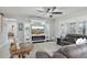 Cozy living room with a fireplace, entertainment center, plush seating, and abundant natural light at 18327 N Summerbreeze Way, Surprise, AZ 85374