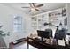 Well-lit home office with custom shelving, a spacious desk, and a comfortable workspace at 18327 N Summerbreeze Way, Surprise, AZ 85374