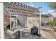 Inviting outdoor patio with a lattice-covered pergola, comfortable seating, and a grill, perfect for entertaining guests at 18327 N Summerbreeze Way, Surprise, AZ 85374