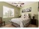 Bedroom with ceiling fan and decorative bedding on bed, and desert artwork on walls at 19932 N Ibis Way, Maricopa, AZ 85138