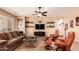 Open living space with a brown sofa, leather chairs, and tile floors at 19932 N Ibis Way, Maricopa, AZ 85138