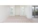 Airy living room boasts neutral carpet, large windows, and access to a private balcony at 200 E Southern Ave # 117, Tempe, AZ 85282