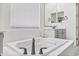 Soaking tub with black fixtures, complemented by large mirrors, tiled floors and bright natural lighting at 22744 E Stonecrest Dr, Queen Creek, AZ 85142