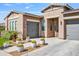 Inviting desert home featuring a three-car garage and well-maintained front yard with unique cactus accents at 22744 E Stonecrest Dr, Queen Creek, AZ 85142