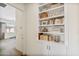 Bright hallway features built-in shelving and a glimpse into a sunlit room, adding functionality and style at 22744 E Stonecrest Dr, Queen Creek, AZ 85142